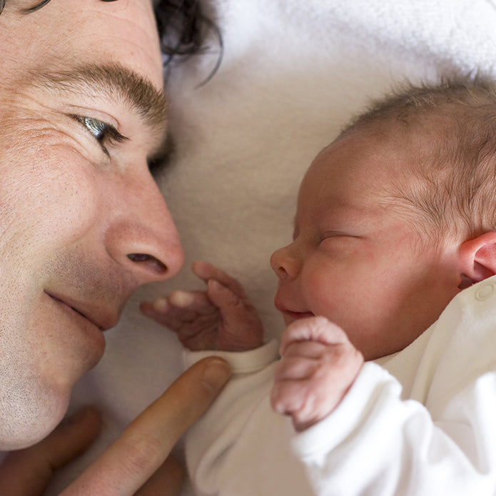 A dad cuddling with his newborn.